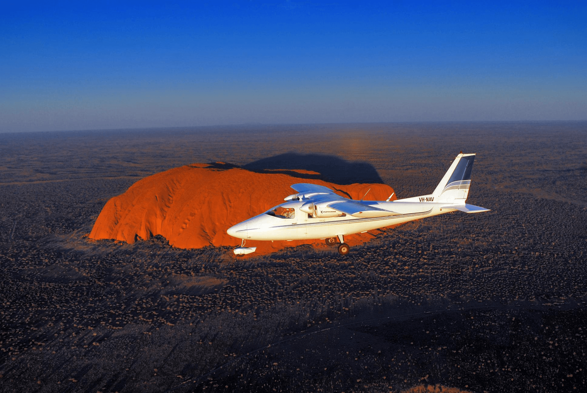 plane in the air over Ayers Rock