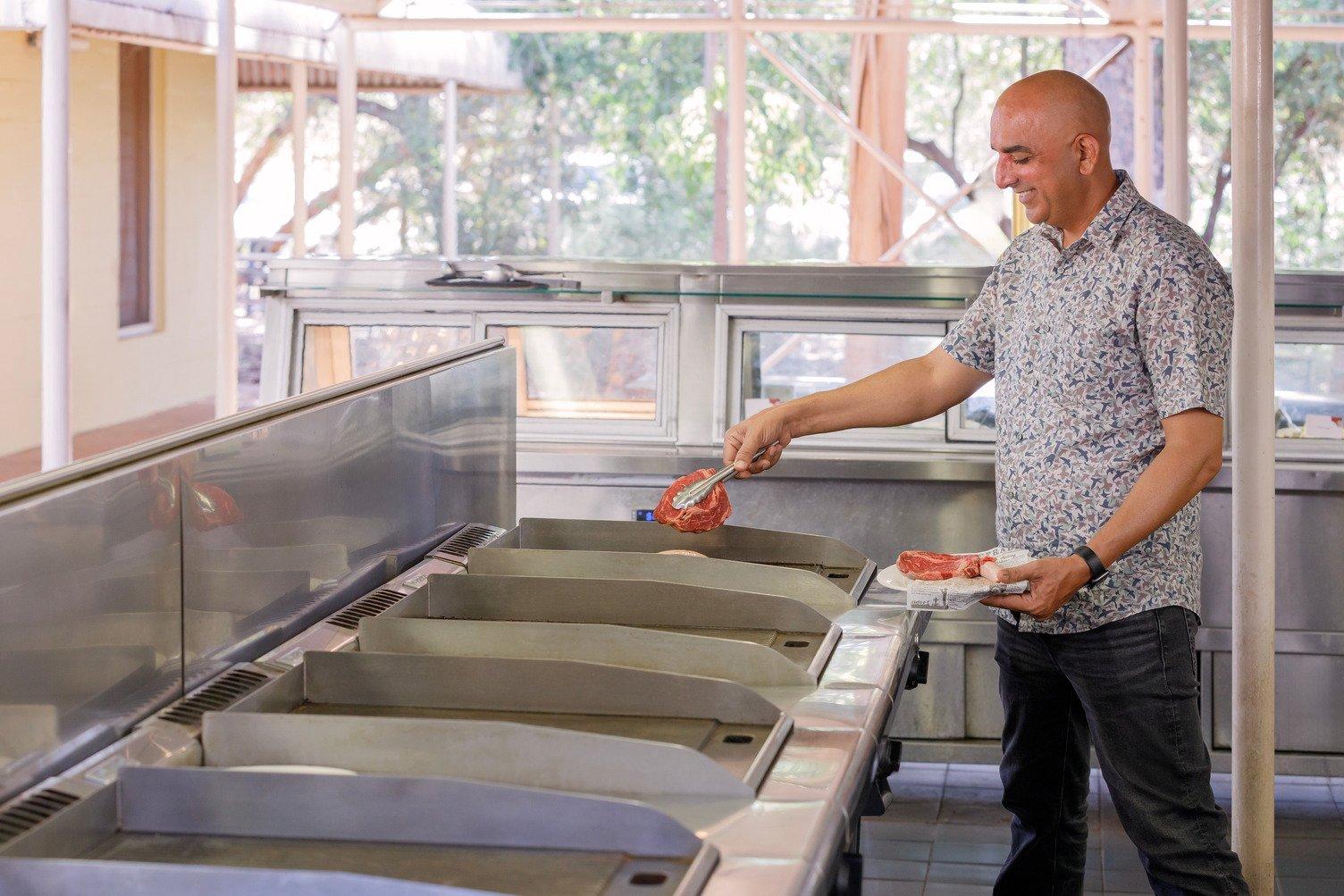 A man cooking a steak on the do it yourself BBQs