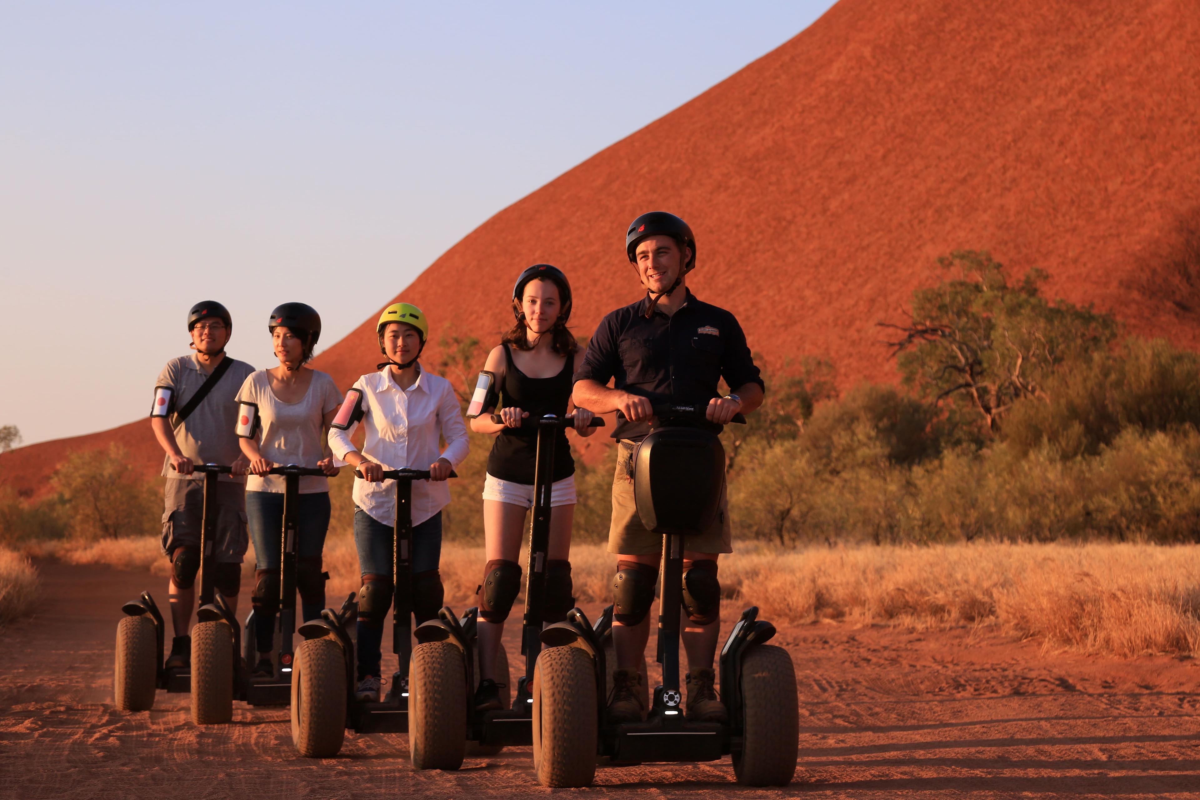 Group of guests on a guided Segway tour at the base of Uluru