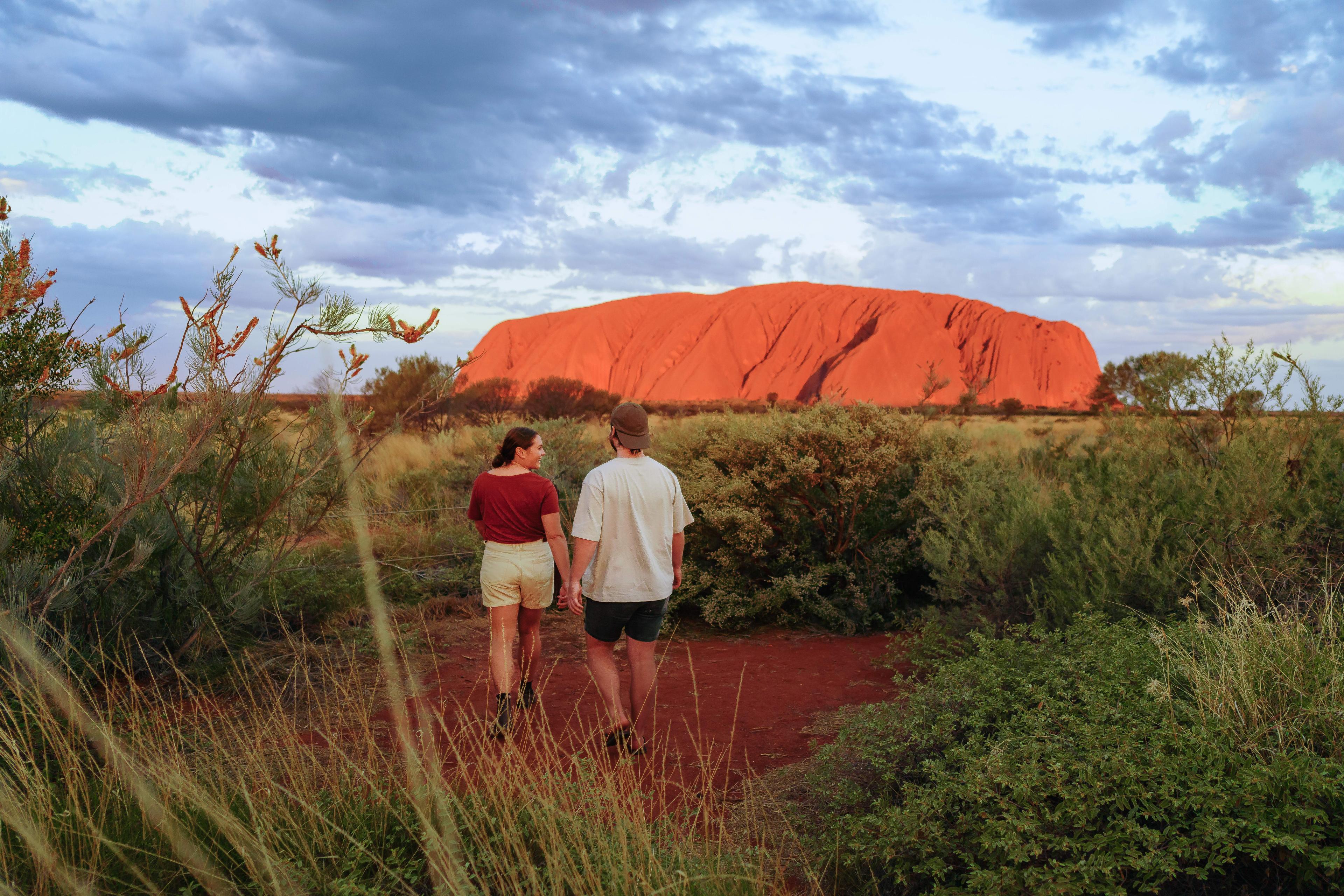 Couple walking in front of Uluru