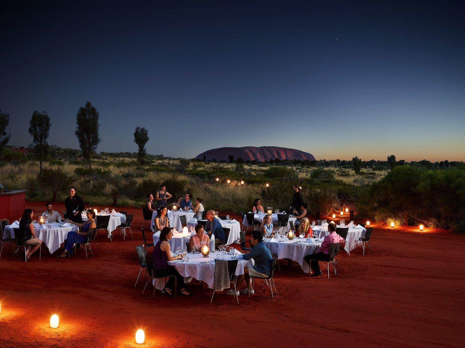 Groups of people having dinner outside at sunset