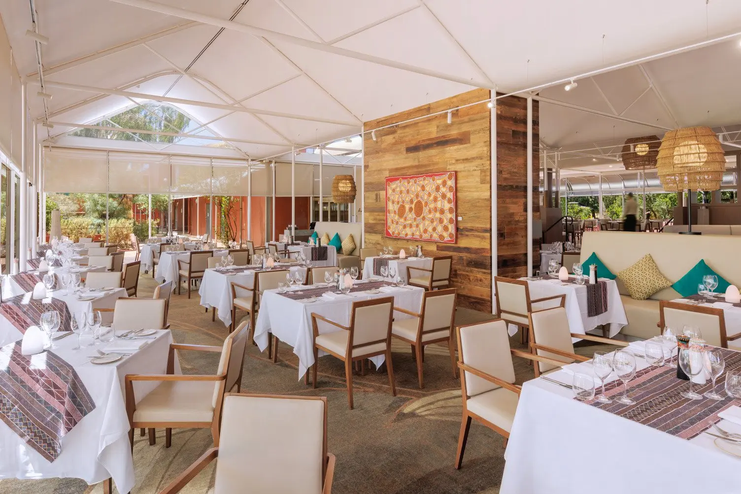 A widespan image of the Arnguli Grill Restaurant with a beautiful indigenous painting in the background.
