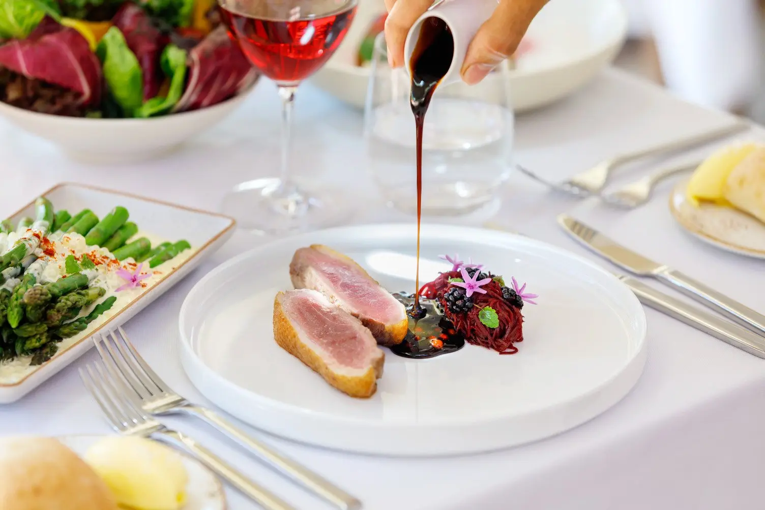 An image of sauce being poured over a a delicious meal at Arnguli Grill