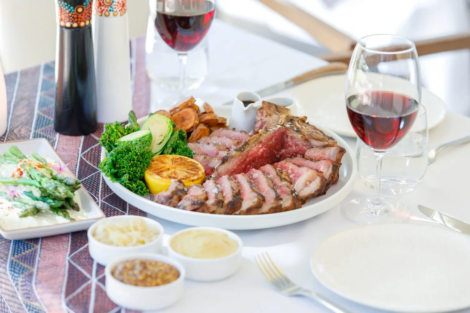 A beautifully curated meal in a bowl with red wine and three sauces at Arnguli Grill