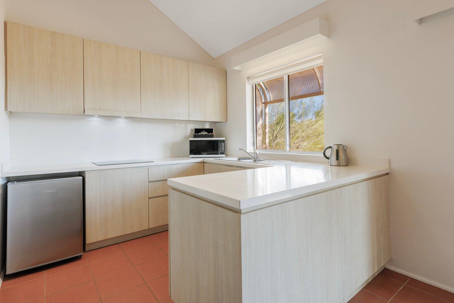 Kitchen with large benchtop, dishwasher, microwave, kettle and sink