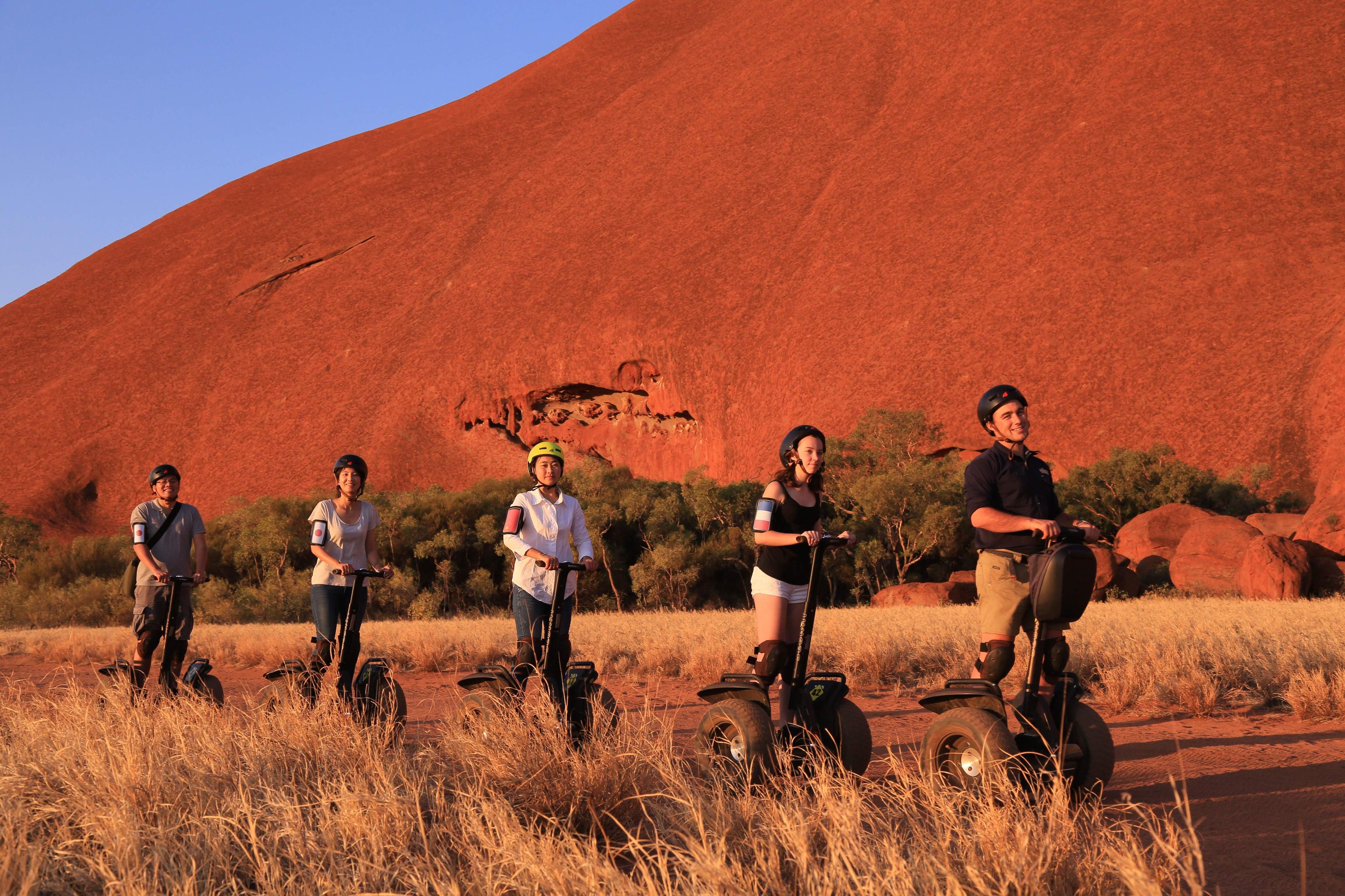 Group of guests on a guided Segway tour at the base of Uluru