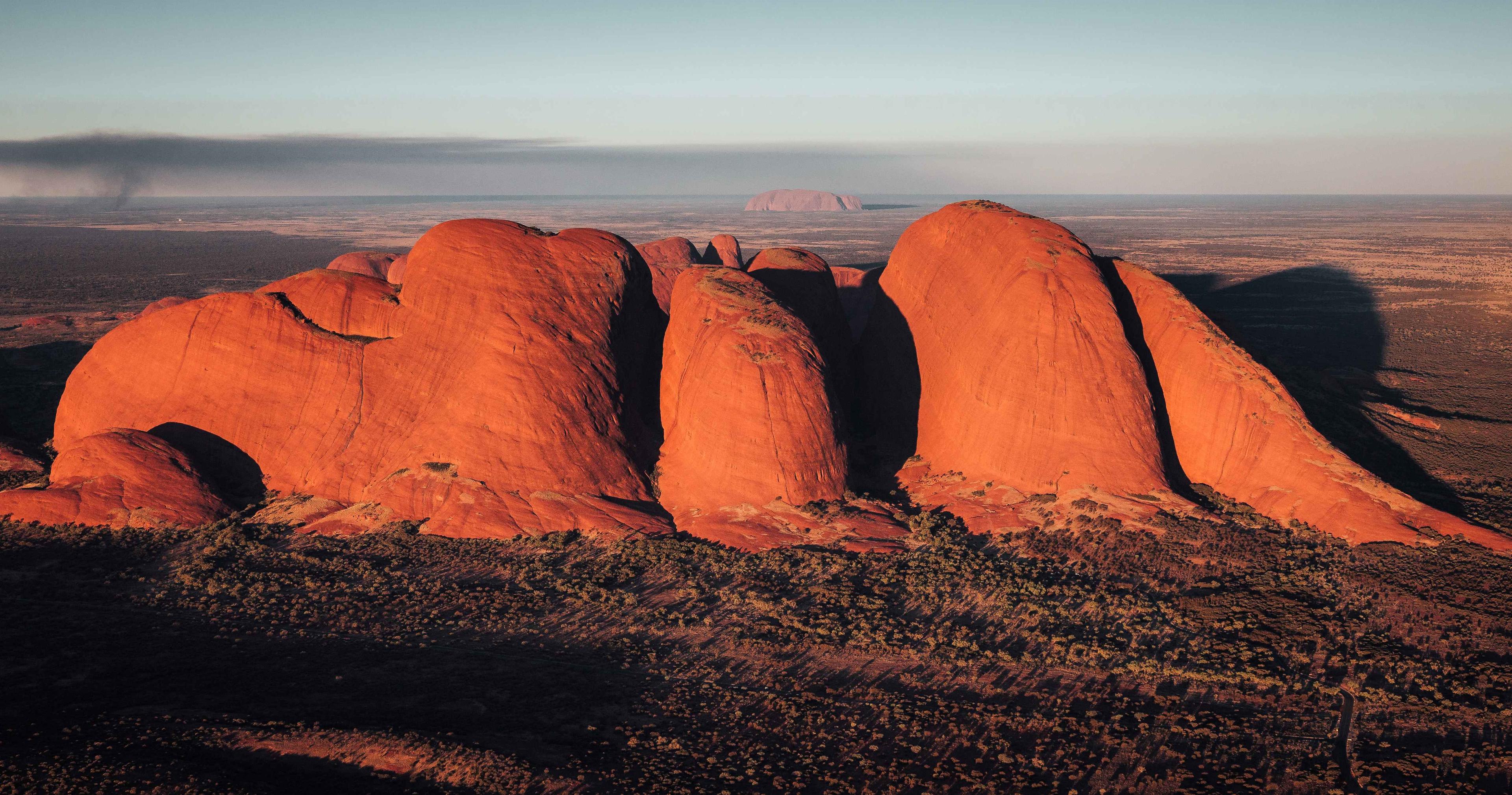 ariel view of uluru kata tjuta glowing at sunrise
