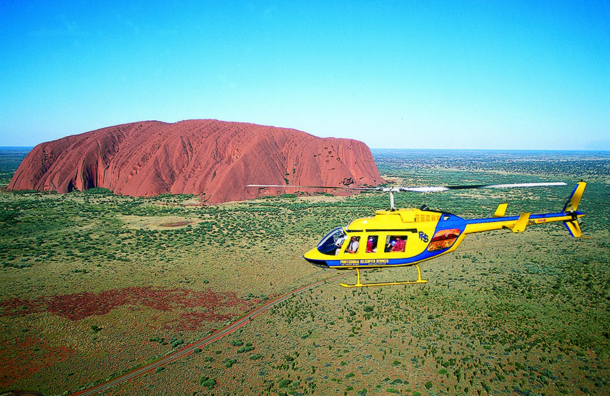 helicopter in flight by Ayers Rock