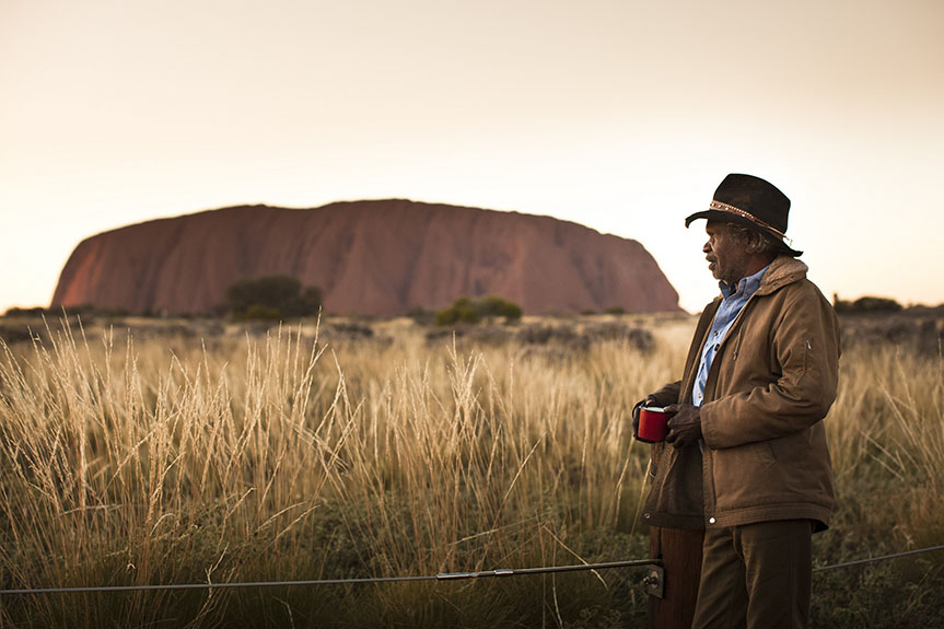 An Anangu man looks at Uluru
