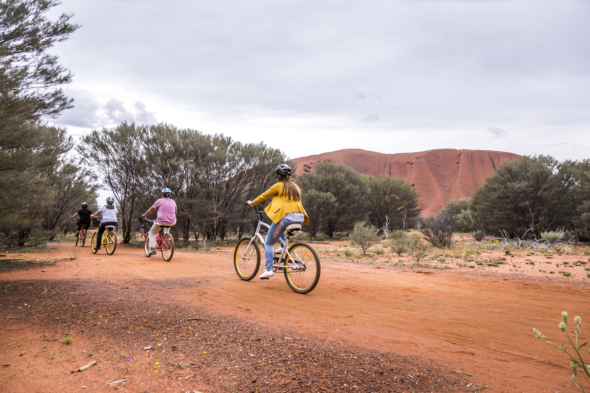 people cycling by Uluru