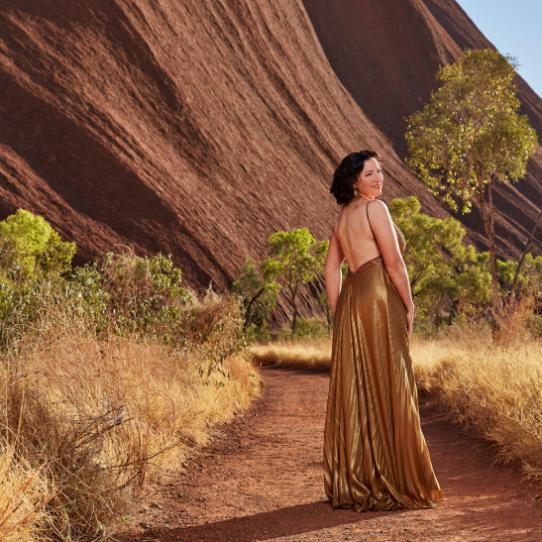 Woman in a dress beside Uluru