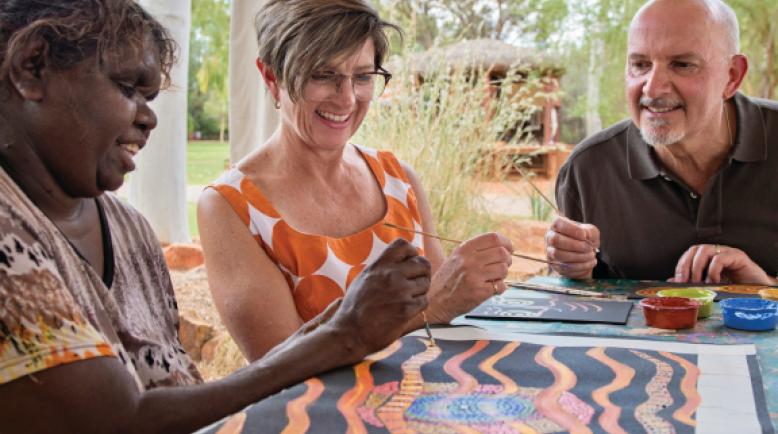 Making indigenous art; three people making Australian indigenous art by hand