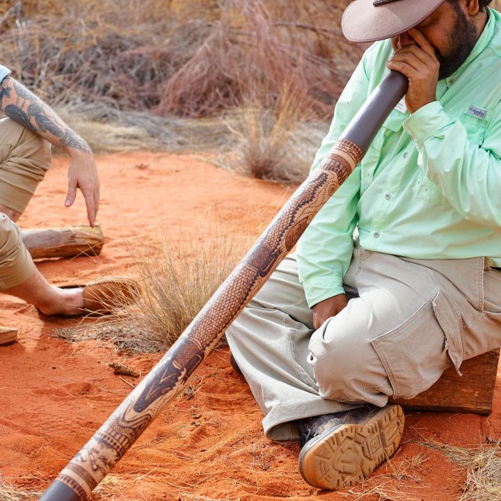 Didgeridoo being played by man in the outback
