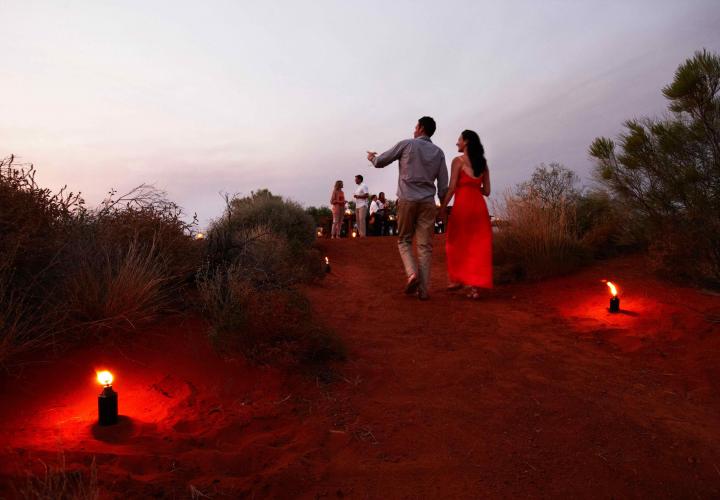 couple on red sand pathway at Ayers Rock resort