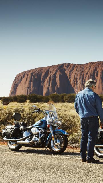 visitors on a Harley with uluru in the background